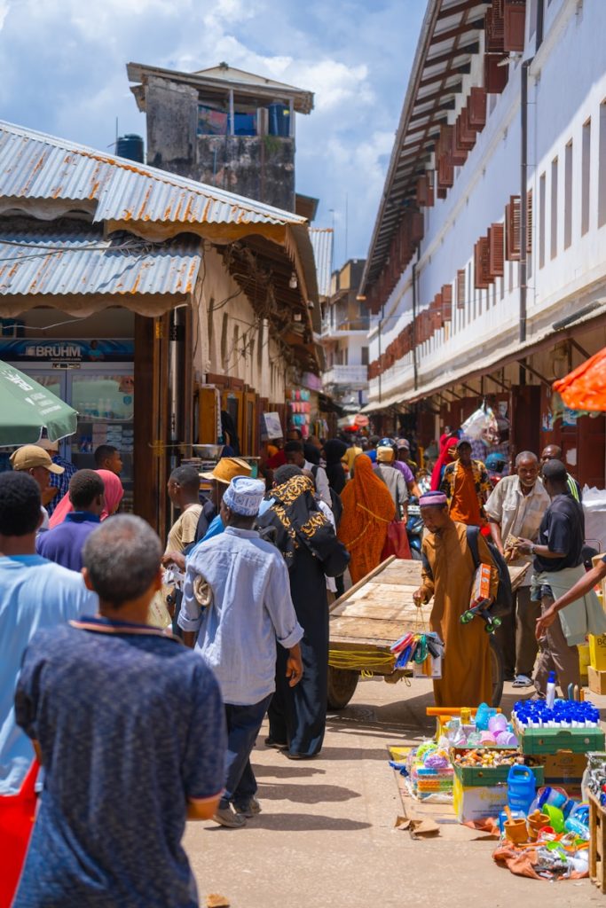 Photo by Aron Marinelli Simba Vanilla Tanzania a group of people walking around a market